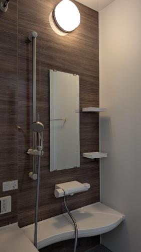 a bathroom with a mirror on a wall with a sink at Yomitan 4LDK house in Yomitan