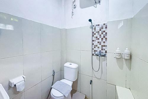 a white bathroom with a shower and a toilet at Garden View near Batu Tulis RedPartner in Bogor