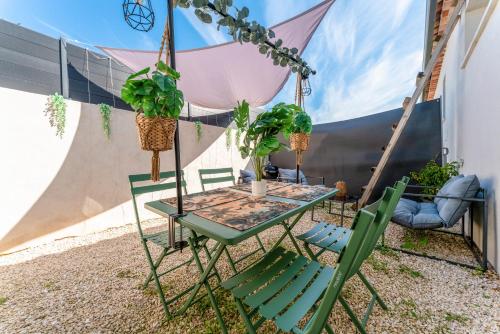 a table and chairs with plants on a patio at Une parenthèse en luberon, jacuzzi in Les Taillades