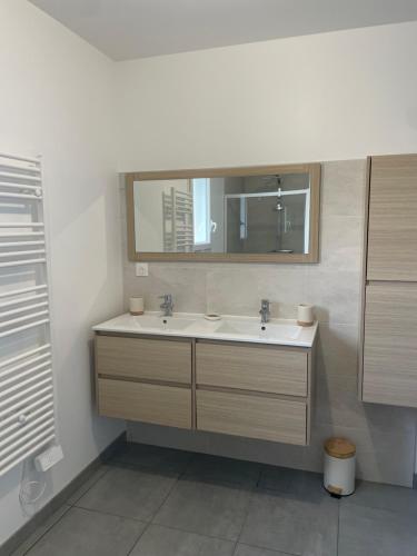 a bathroom with a sink and a mirror at villa Emilie in Trélissac