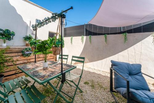 a patio with a table and chairs and a ramp at Une parenthèse en luberon, jacuzzi in Les Taillades