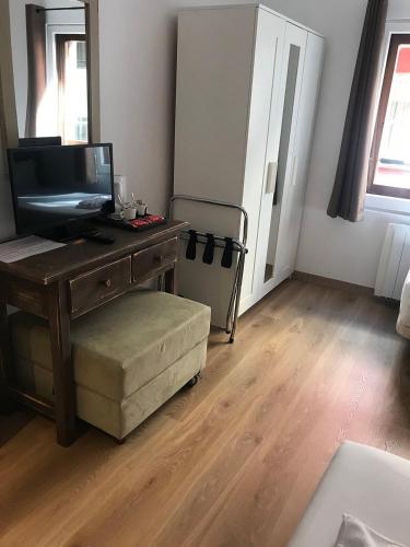 una habitación con un escritorio y una silla y un televisor en Hotel KATHMANDU - PANDA, en Pas de la Casa