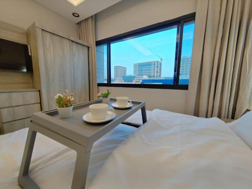 a bedroom with a bed and a table with cups and saucers at استوديو السعودية - التحلية 411 Saudi Studio -Tahlia in Jeddah