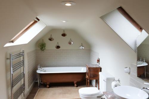 a bathroom with a tub and a toilet and a sink at The Coach House in Castle Douglas