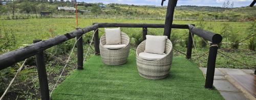 three wicker chairs with pillows sitting on the grass at The Lantern Gardens - Oloirien in Kiserian