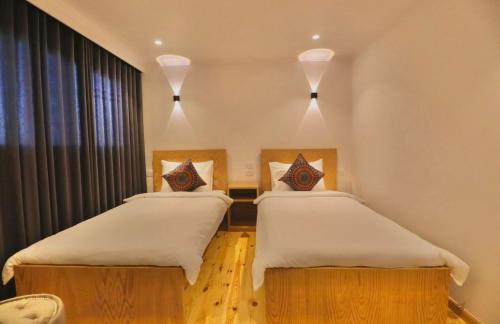 two twin beds in a room with a window at Cobra Nile Sails - Tranquility in Luxor