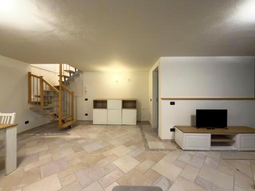 a living room with a television and a staircase at Montanari Palace in Mirandola