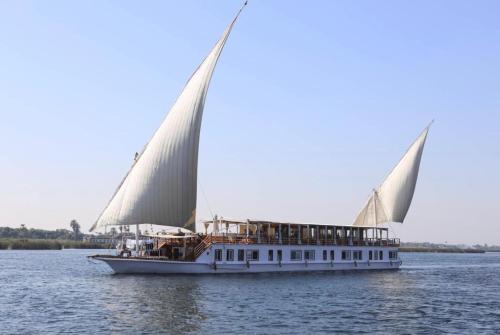 a boat with two large sails on the water at Cobra Nile Sails - Tranquility in Luxor