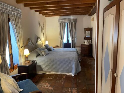 a bedroom with a bed and two windows at Posada La Llosa de Somo in Somo
