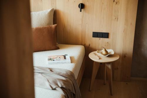 a small table next to a bed in a room at Taubers Bio Vitalhotel in Chienes