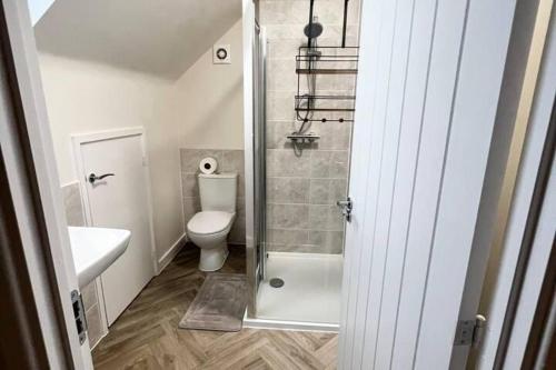 a small bathroom with a toilet and a shower at 3-Bed House Sleeps 5 Free Parking in Bradford