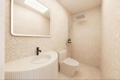 a bathroom with a sink and a toilet and a mirror at A Hotel Farrer Park - Newly Renovated in Singapore
