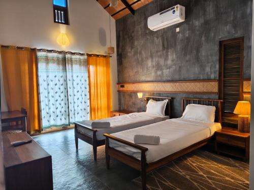 una camera da letto con due letti in una stanza di Birdwing - Experiential Farmstay Resort by GoodEarth 