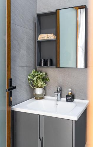 a bathroom with a white sink and a mirror at TT House Pleiku in Plei Kêp