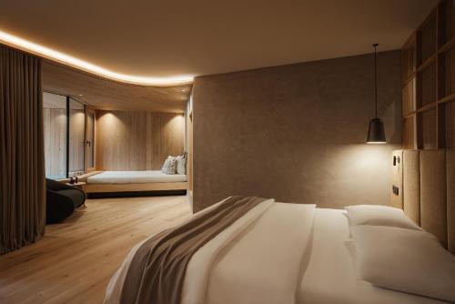 a bedroom with a bed and a couch in a room at Taubers Bio Vitalhotel in Chienes