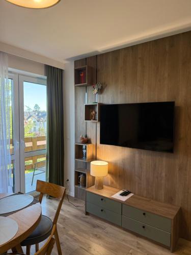 ein Wohnzimmer mit einem Flachbildfernseher an der Wand in der Unterkunft Przytulny Zakątek Karkonoszy in Karpacz
