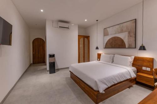 a bedroom with a large bed and a television at Casa del Canggu 1 - 1 bedroom villa in Pererenan