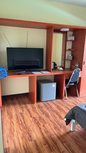 an office with a desk with a television and a chair at กุลทีปโฮสเทล in Pathum Thani