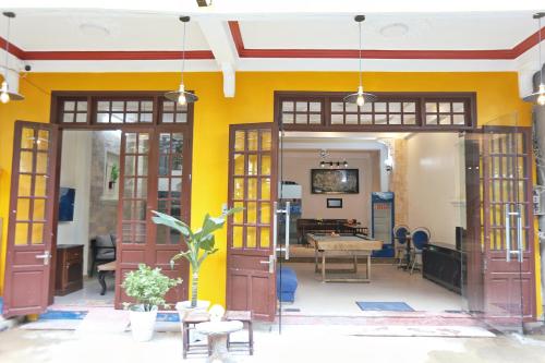 a room with doors and a yellow wall at Hue Imperial Hostel in Hue