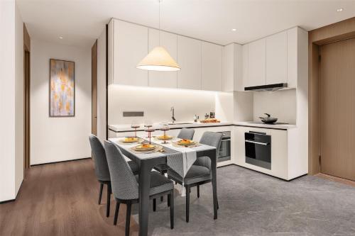 a kitchen and dining room with a table and chairs at Ascott Fengyishan Shenzhen in Shenzhen