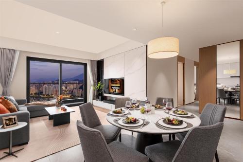 a dining room and living room with a table and chairs at Ascott Fengyishan Shenzhen in Shenzhen