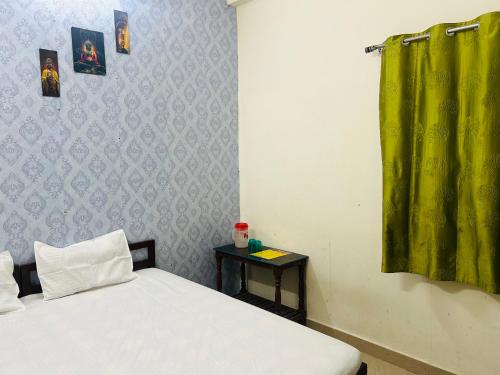 a bedroom with a bed and a green curtain at Ganpati Guest House Near Ram Jhula in Rishīkesh