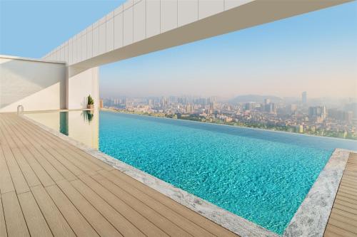a swimming pool on the roof of a building with a city at Ascott Fengyishan Shenzhen in Shenzhen