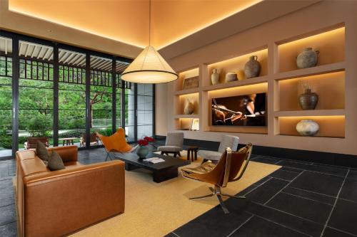 a living room with a couch and chairs at Ascott Fengyishan Shenzhen in Shenzhen