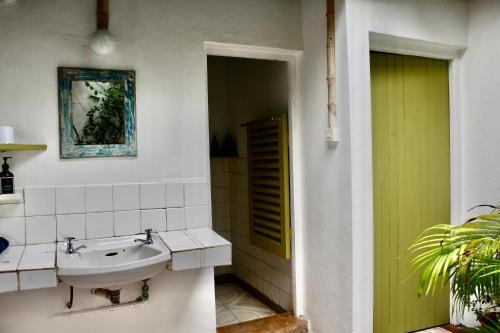a bathroom with a sink and a green door at Salty's Kitesurf Village in Kilifi