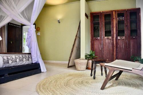 a room with a bed and a table and a door at Salty's Kitesurf Village in Kilifi