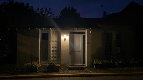 a house with a light on the side of it at night at Agréable petit gîte avec jardinet et piscine in Salies-de-Béarn