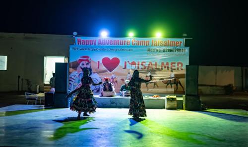 two women on the stage in front of a sign at Happy Adventure Camp & Resort Sam Jaisalmer in Sām