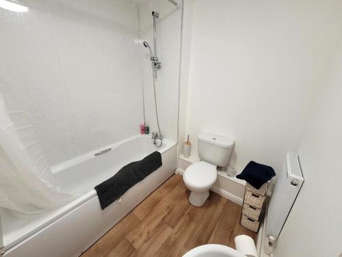 une salle de bain avec une baignoire blanche et des toilettes dans l'établissement Hythe House - Stylish Stay for Families & Groups by Catchpole Stays, à Colchester