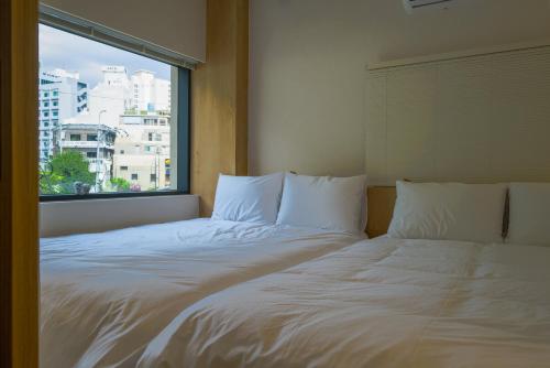 a bed in a room with a large window at Trip made in Busan