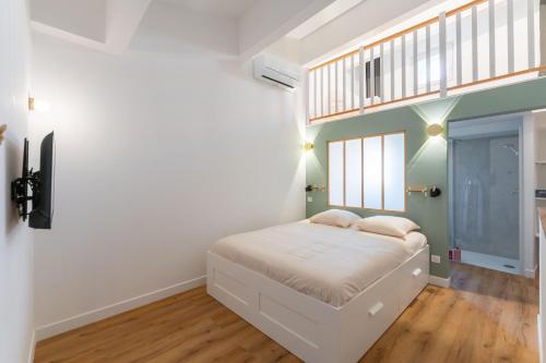 ein kleines Schlafzimmer mit einem weißen Bett und einem Fenster in der Unterkunft Duplex Labet in La Ciotat