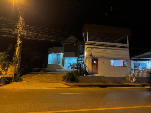 a small white building with a door on a street at night at Serenity House 4A in Ban Nong Chaeng