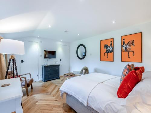 a bedroom with a bed and four pictures of horses on the wall at The Studio in Wittersham