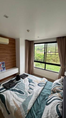 a bedroom with a bed and a window at The Lago apart Nai Harn beach 5min in Rawai Beach