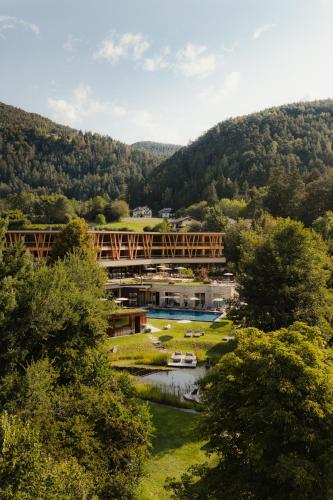 a bridge over a river next to a mountain at Taubers Bio Vitalhotel in Chienes