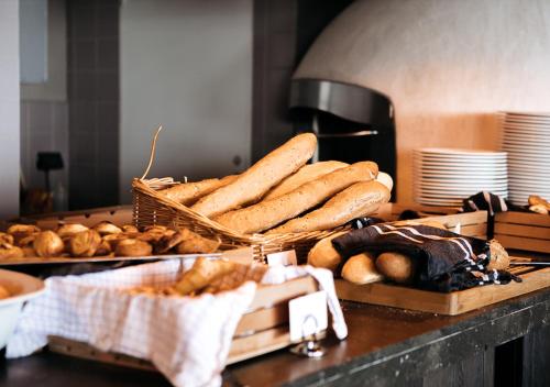 a counter with baskets of bread and baskets of bagels at Langley Hôtel Tignes 2100 in Tignes