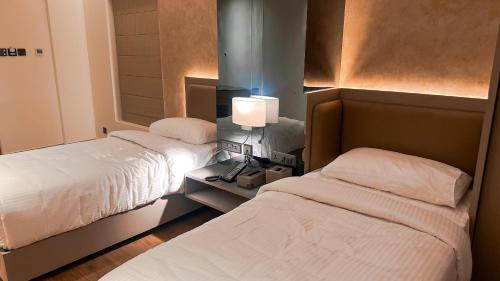 a bedroom with two beds and a lamp on a table at FHotels in Bengaluru