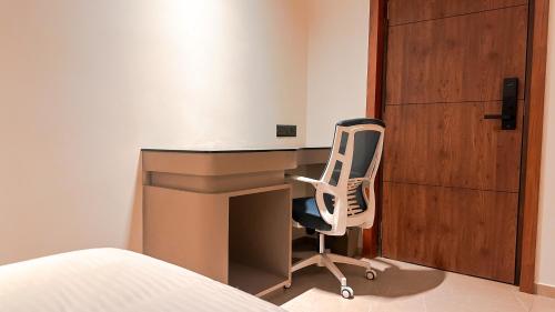 a bedroom with a desk and a chair next to a bed at FHotels in Bengaluru