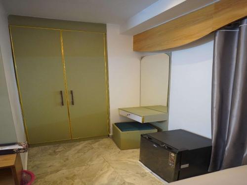 a small room with a green closet and a bed at Hotel The Light Park in Chittagong