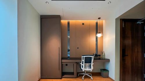 a room with a chair and a desk and a mirror at FHotels in Bengaluru