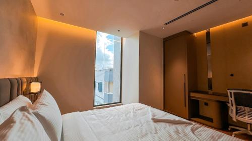 a bedroom with a bed and a large window at FHotels in Bengaluru