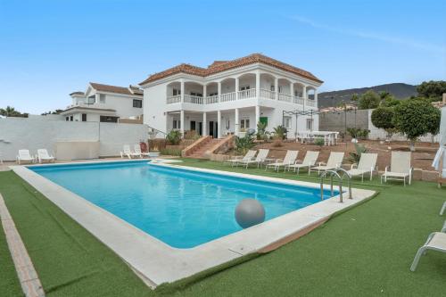 a large house with a swimming pool in front of it at Villa Luxury el Mirador in Adeje