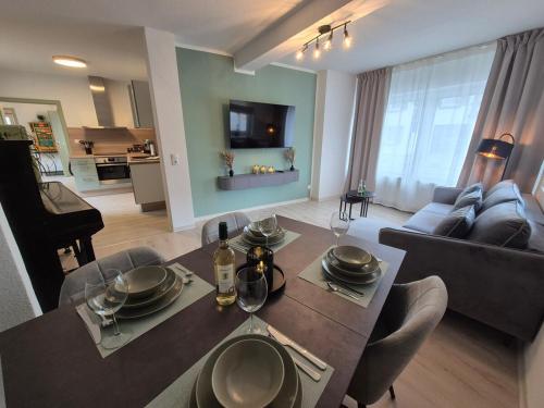 Un comedor y una sala de estar con mesa y sillas. en NAVIA Luma - Design Apartment - Stylisch, voll ausgestattet, mit Parkplatz, en Dernbach