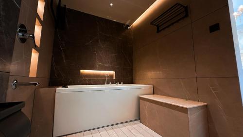 a bathroom with a bath tub and a toilet at FHotels in Bengaluru