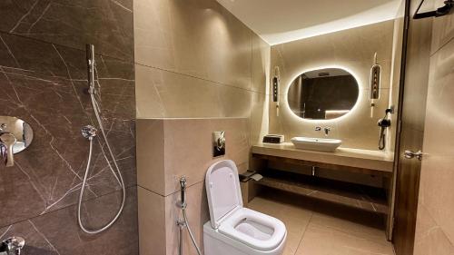 a bathroom with a toilet and a sink and a shower at FHotels in Bengaluru