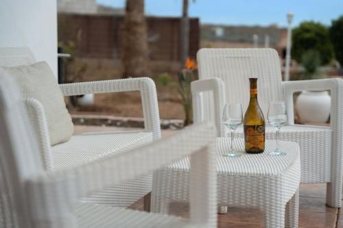 a bottle of wine sitting on a table with two glasses at Villa Luxury el Mirador in Adeje